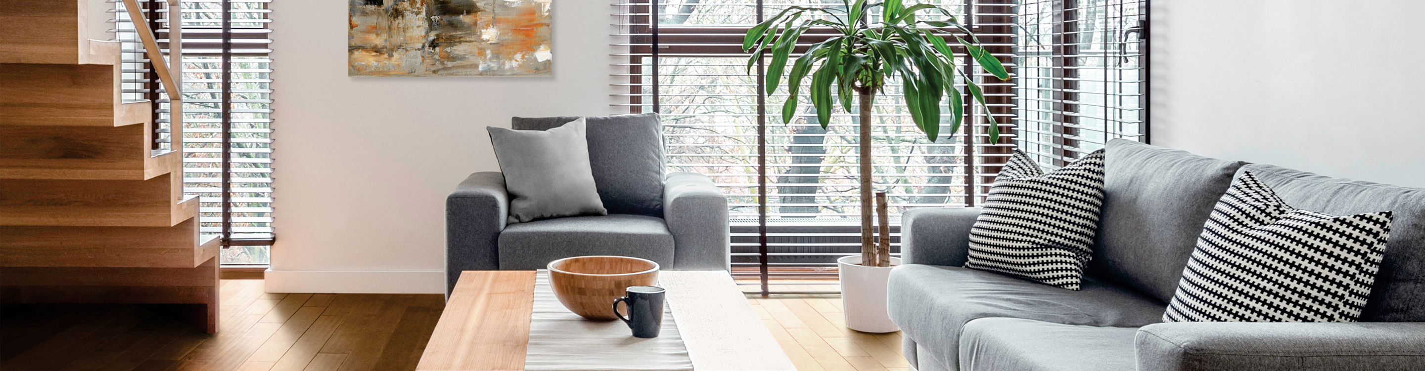 blinds in living room with wood flooring and grey armchair, sofa