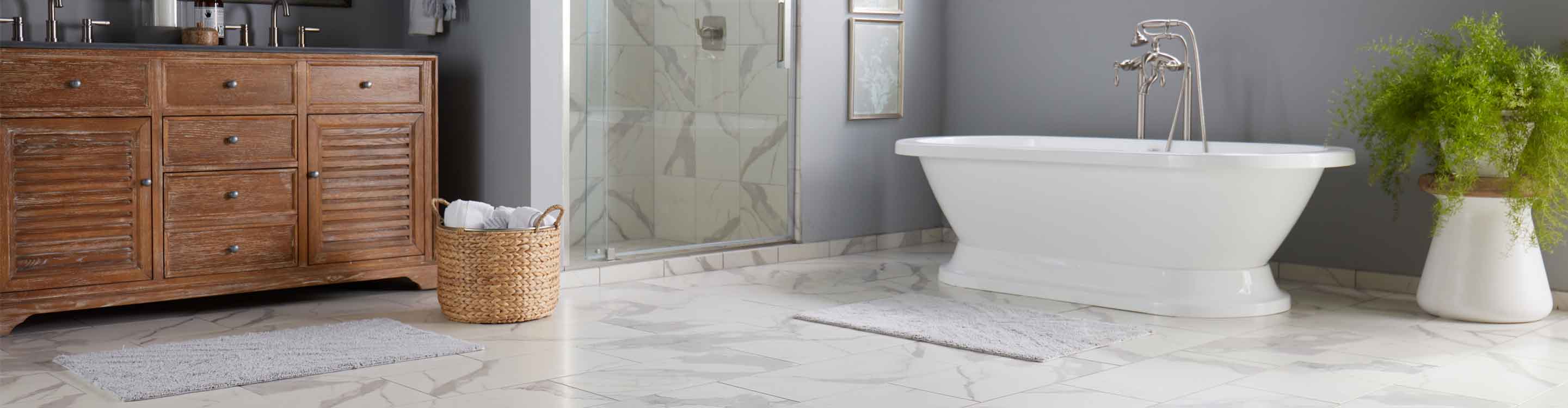 Bathroom, tile flooring, plant next to white tub, glass shower